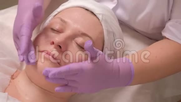 美容院女性面部化妆程序肌肤的焕新效果特写镜头他的手视频的预览图