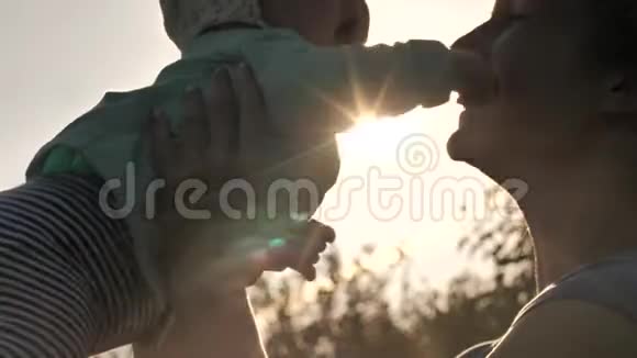 快乐的孩子交到妈妈手中家人拥抱日落视频的预览图