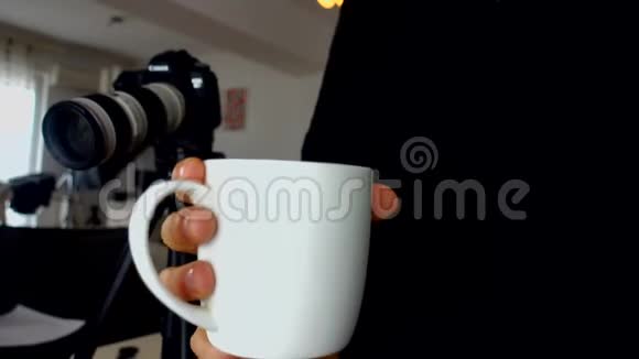 自由摄影师拿着一杯咖啡背景是dslr相机视频的预览图