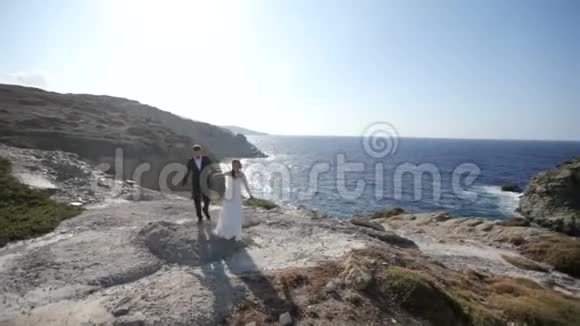 新婚之日在海边的新郎新娘快乐慢动作视频的预览图