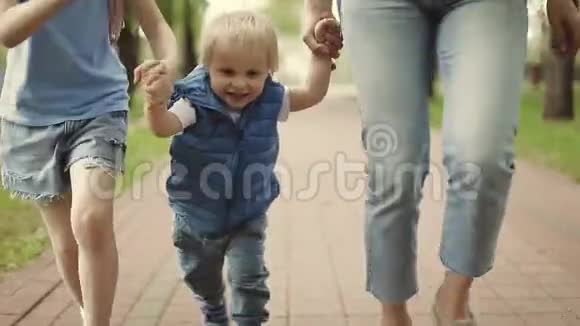 妈妈带着一个小儿子和女儿在公园里跑步视频的预览图