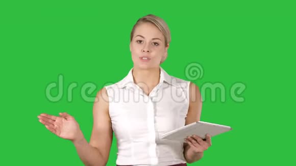 一位职业经理人的肖像一位成熟的女商人拿着平板电脑在绿色屏幕上与摄像机交谈视频的预览图