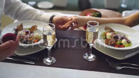 在餐厅的浪漫晚餐上求婚时女性手指上戴着漂亮戒指的特写镜头视频的预览图