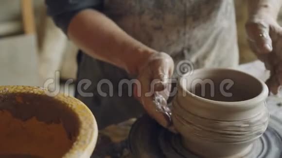 男陶工集中在用粘土在纺车上做锅他正在改正陶器的形状视频的预览图