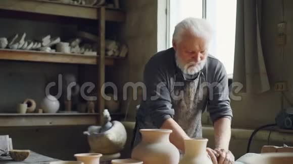 经验丰富的陶工正在车间的工作台上用手捏泥创造餐具手工用具视频的预览图