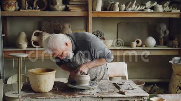 熟练的老年陶工在工作场所的转盘上生产陶瓷锅创造过程传统陶器视频的预览图