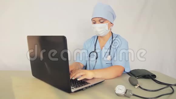 女医生坐在他的办公桌前用笔记本电脑工作照相机从左到右移动到小车上视频的预览图