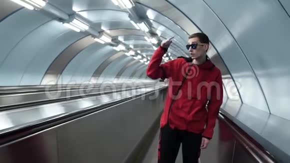 穿着红色夹克和太阳镜的有魅力的男性在旅行家讲话视频的预览图