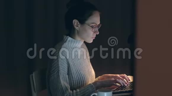 活跃的女性自由职业者晚上在笔记本上工作视频的预览图