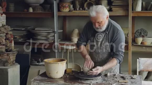 创意男陶器正在形成不对称的大碗在投掷轮同时在小车间工作创造力视频的预览图