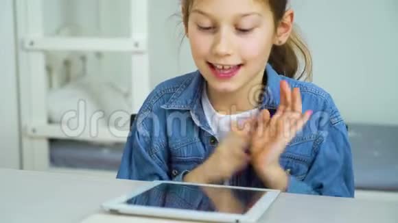 快乐的小女孩在网上玩游戏时触摸平板电脑屏幕视频的预览图