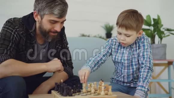 爱的爸爸正在和他的孩子下棋教他规则和他说话抚养孩子智力视频的预览图