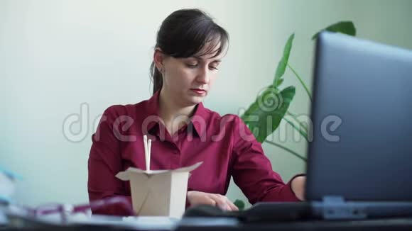 工作时吃面条的忙碌妇女视频的预览图