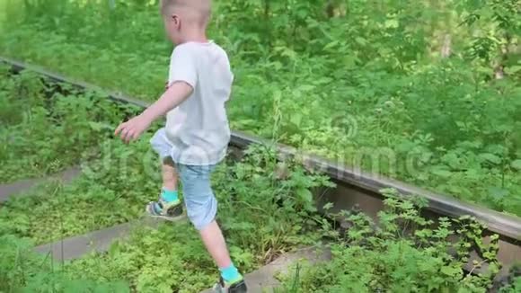 孤独的男孩在铁轨上跑来跑去危险的游戏和娱乐视频的预览图