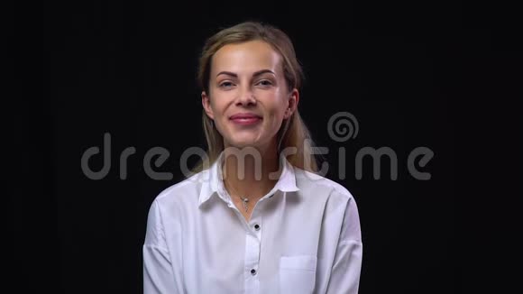 穿白衬衫的女人在黑色背景下微笑视频的预览图