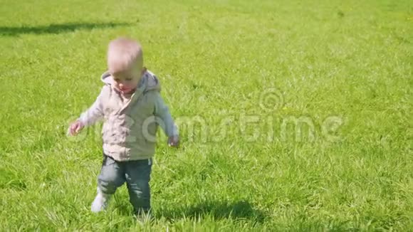 金发幼儿在绿草上奔跑慢镜头视频的预览图