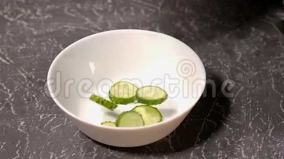 黄瓜在灰色背景的白色盘子里被切开视频的预览图