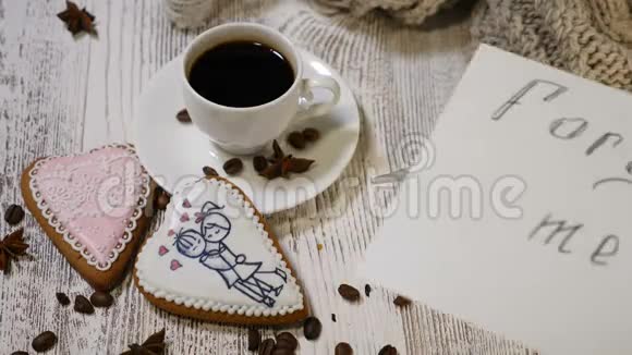 乞求原谅恋爱关系咖啡杯和姜饼干心形木背景的俯视图视频的预览图