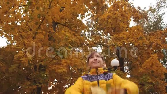 十几岁的女孩在秋天扔枫叶微笑着慢动作视频的预览图