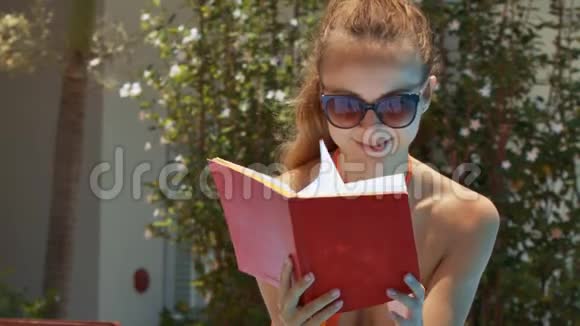 戴太阳镜的金发女郎在布什身边读书视频的预览图