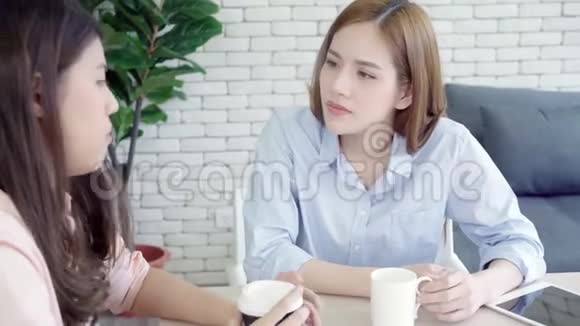 亚洲商界女性喜欢喝热咖啡讨论工作和闲聊八卦同时放松在办公室工作视频的预览图