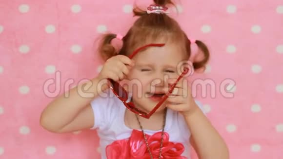 魅力四射时尚美丽一个可爱的孩子时尚扮演一个真正的女士粉色背景漂亮的小女孩穿红色衣服视频的预览图