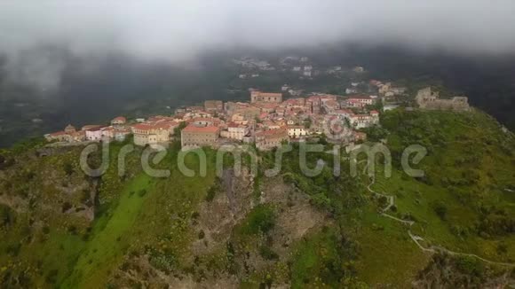 在山上俯瞰一座山峡的古城鸟瞰古老的砖石建筑上低雨云视频的预览图