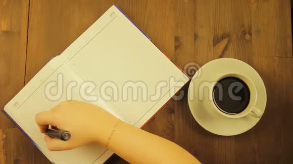 女孩在日记里用黑色记号笔写爱的字喝咖啡视频的预览图