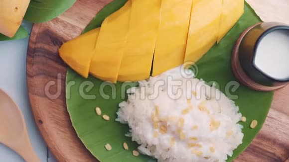 泰国芒果和糯米泰国甜点是由成熟的芒果和糯米煮至熟撒上椰奶视频的预览图
