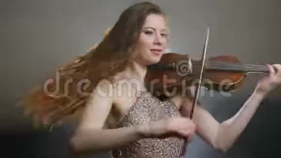 年轻女孩在乐器上演奏在爱乐中旋转视频的预览图