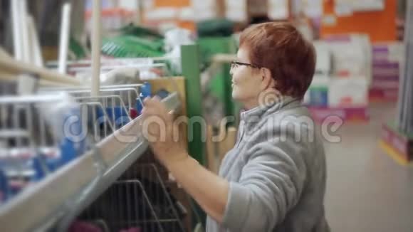 在百货公司的一家超市里一位老年妇女选择了必要的园艺设备视频的预览图