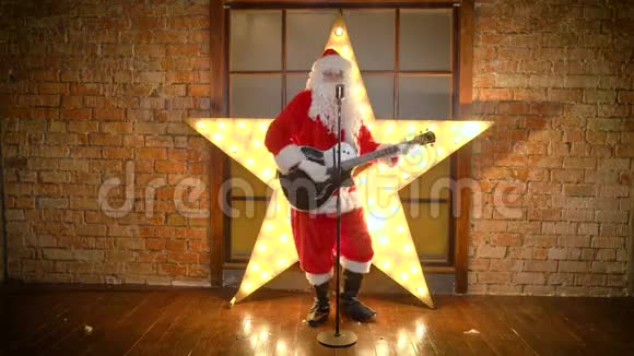 圣诞老人摇滚明星弹吉他用复古麦克风唱有趣的圣诞歌曲视频的预览图