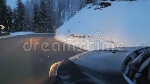 现代汽车车前灯在道路上沿雪覆盖的树木和山丘视频的预览图