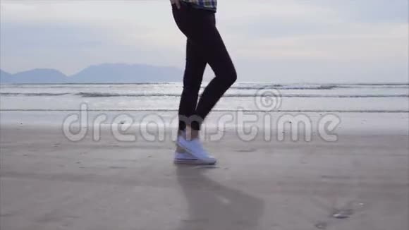 女子在潮湿的海岸上行走时动作缓慢视频的预览图