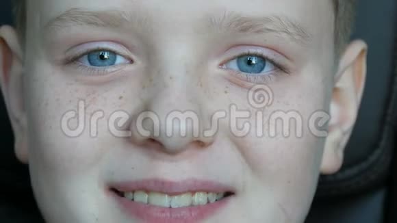 一个开朗的金发男孩脸上长着雀斑蓝眼睛看着摄像机笑得很开心视频的预览图