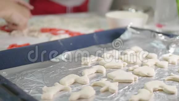 小女孩在厨房帮妈妈做饼干在厨房做不同形状的饼干视频的预览图