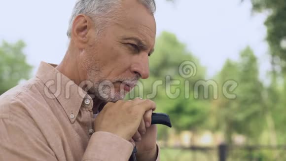 有思想的退休男子带着拐杖在公园社会保障养老金年龄视频的预览图