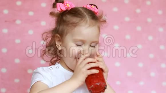 快乐可爱的小女孩喝覆盆子冰沙和微笑素食饮料儿童的特写镜头视频的预览图