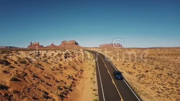 蓝色皮卡车经过无人机相机在空旷的沙漠公路道路在亚利桑那州与惊人的平坦的山脉天际线视频的预览图