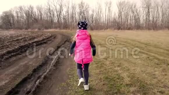 一个小女孩在田野里跑来跑去春天的一天视频的预览图