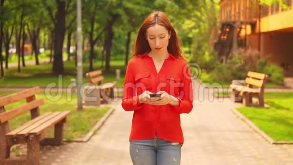 一个红头发的女商人拿着移动行走视频的预览图