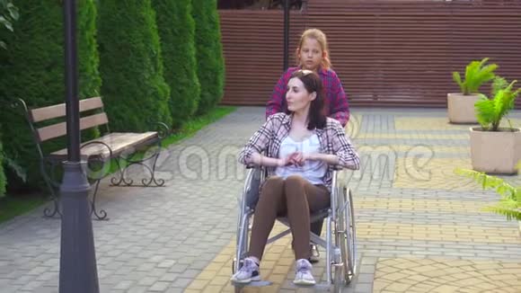 女儿在公园残疾母亲坐在轮椅上稳拍慢拍视频的预览图