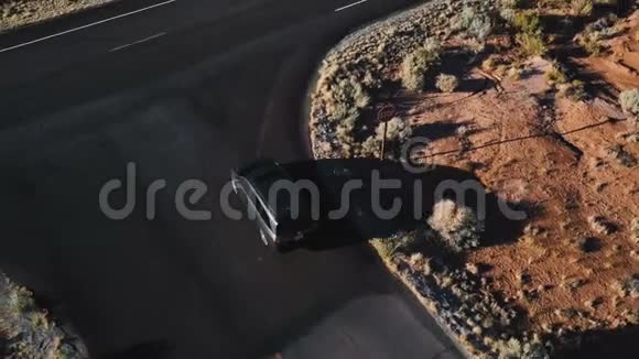 无人机跟随着银色的小型货车沿着不可思议的美国沙漠公路行驶公路上有美丽的岩石山视频的预览图