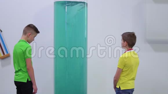 两个男孩在科普博物馆看人造漩涡视频的预览图