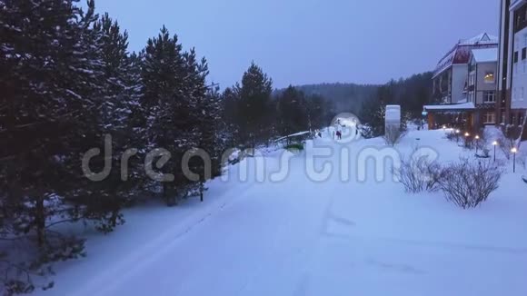 冬天一家人在公园小路上散步剪辑在度假胜地带灯笼的小路上一家人在雪地里散步的最高景观视频的预览图