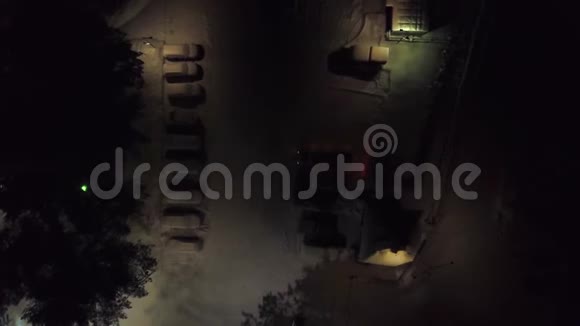 冬季夜间停车场的俯视图剪辑城市停车场冬季夜间有积雪覆盖的汽车和昏暗的灯光视频的预览图