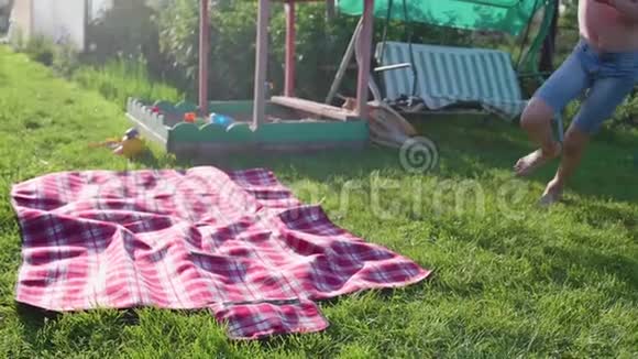两个孩子在炎热的夏天在草坪上玩耍孩子们笑着他们跑着落在草坪上户外娱乐视频的预览图