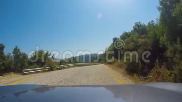 在阳光明媚的夏天汽车在山林道路上转弯视频的预览图