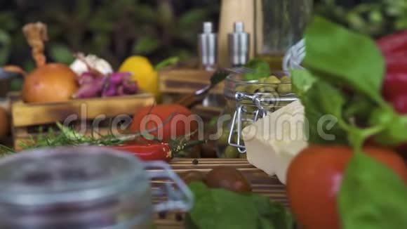 追踪拍摄的食物成分从蔬菜橄榄草药奶酪木制调味料的食物背景视频的预览图