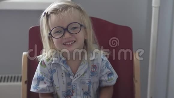 穿着蓝色睡衣和眼镜的小女孩视频的预览图